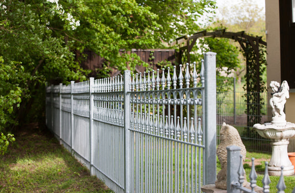 Zaun Lugano in einem Garten neben einer weißen Statue | Feuerverzinkt