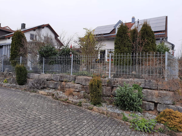Zaun Como auf einer Mauer vor einem Haus mit gepflegtem Garten | Feuerverzinkt